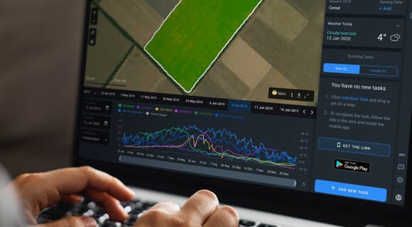 farmer with the laptop using Crop Monitoring app